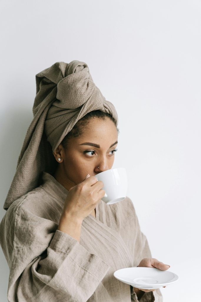 Woman in bathrobe enjoys morning coffee, creating peaceful moments.