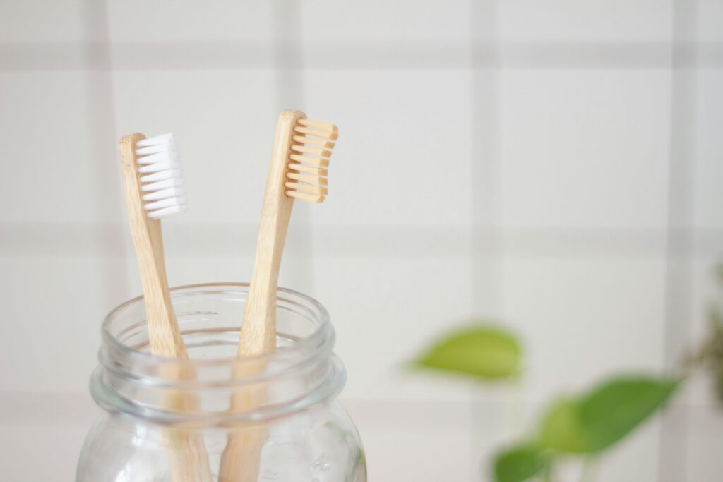 Close-up of bamboo toothbrushes in a glass jar. Perfect for eco-conscious hygiene products.